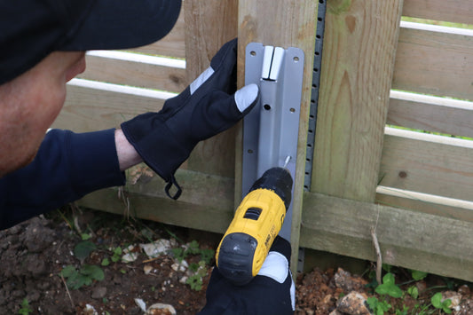 DuraPost® trained installer attaching a Fencemate® repair spur to a wooden fence